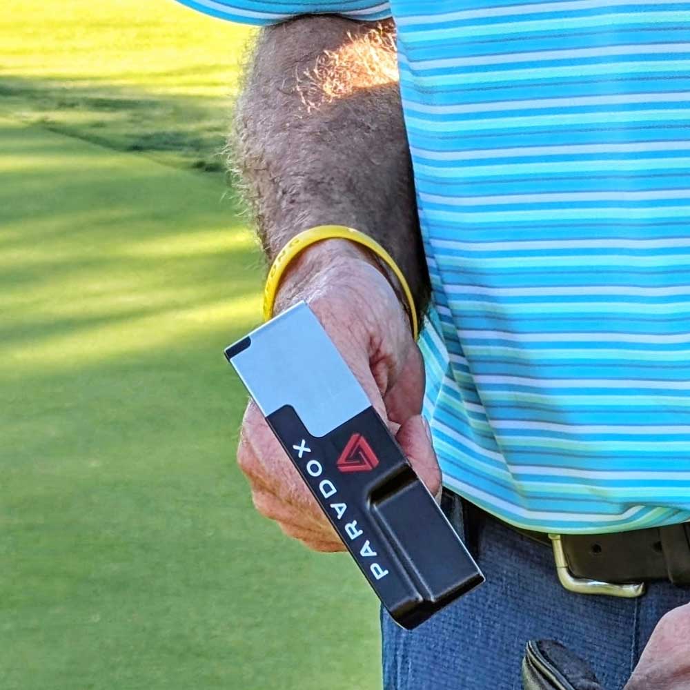 Person holding a paradox whistle on a golf course